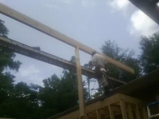 Carpenter setting a ridge beam over a new addition frame — Ice Dam Removal by Roofing Brothers in Manzanita