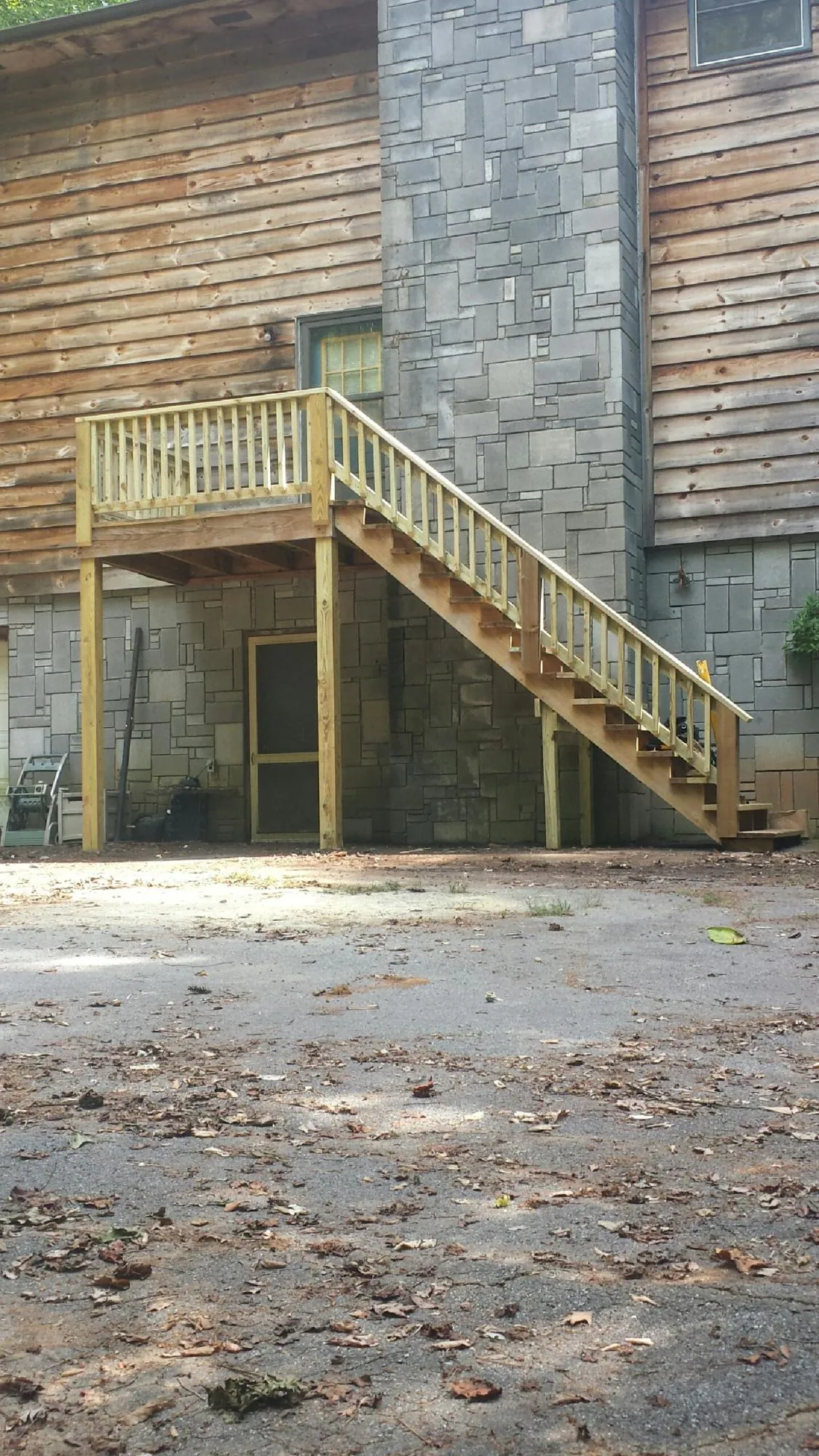 New pressure treated deck and stair landing on a log home in Manzanita